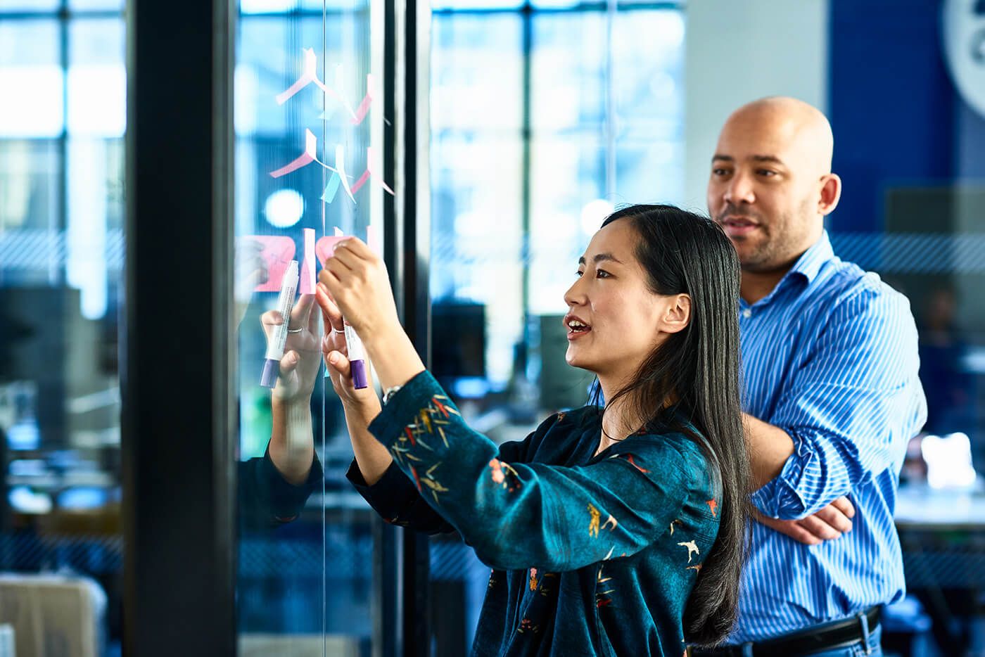 Development - Man and woman brainstorming ideas with post it notes