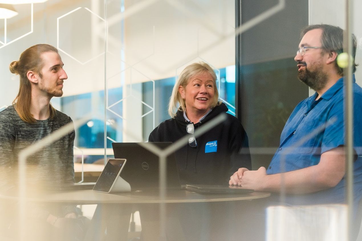 Bupa colleagues working together in a meeting room, reflecting collaboration and teamwork in a professional office setting