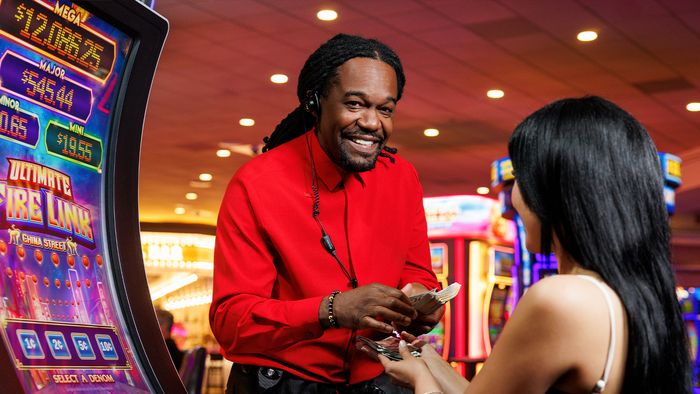 Man handing prize to casino customer